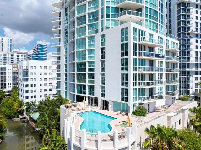a view of a small yard with large trees and plants