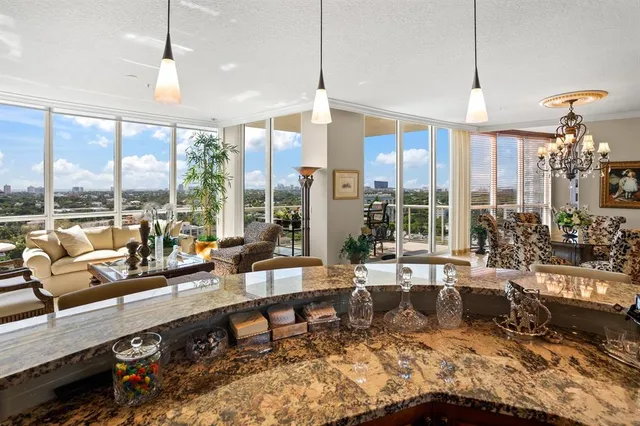a living room with furniture and floor to ceiling windows