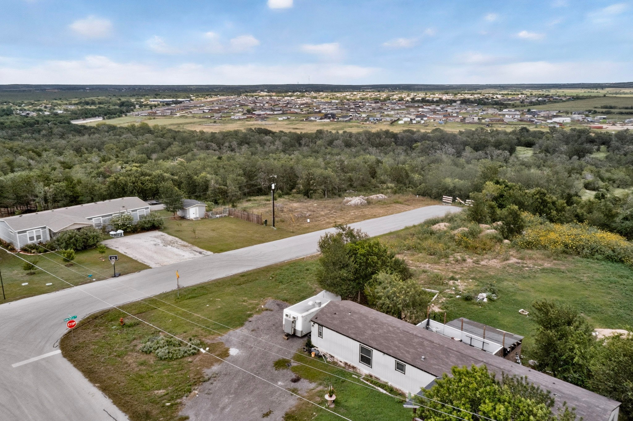 693 Santa Teresa Road Kyle, TX 78640 - Photo 12 of 20 An aerial perspective reveals a vast landscape with residential development nestled among abundant greenery.