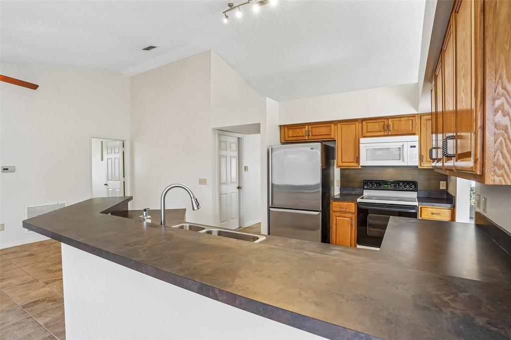 2596 Alclobe Circle Ocoee, FL 34761 - Photo 22 of 70 a kitchen with stainless steel appliances granite countertop a sink and a refrigerator