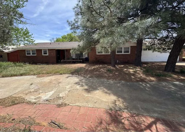 a view of a house with a tree in front of it