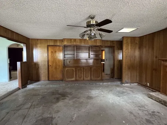 a view of a livingroom with a chandelier fan and a window