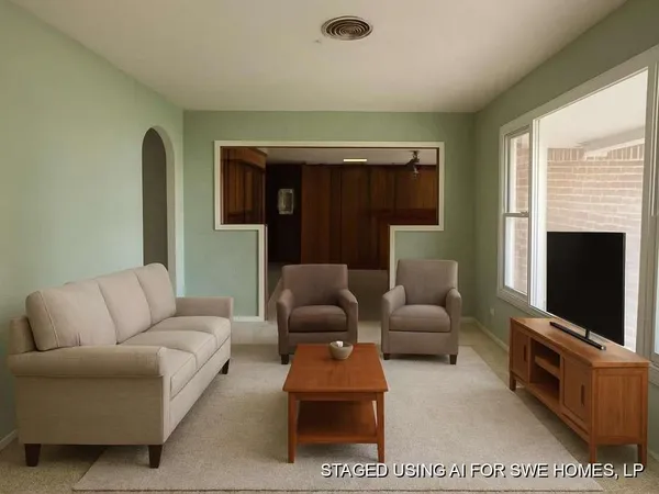 a living room with furniture a flat screen tv and a fireplace