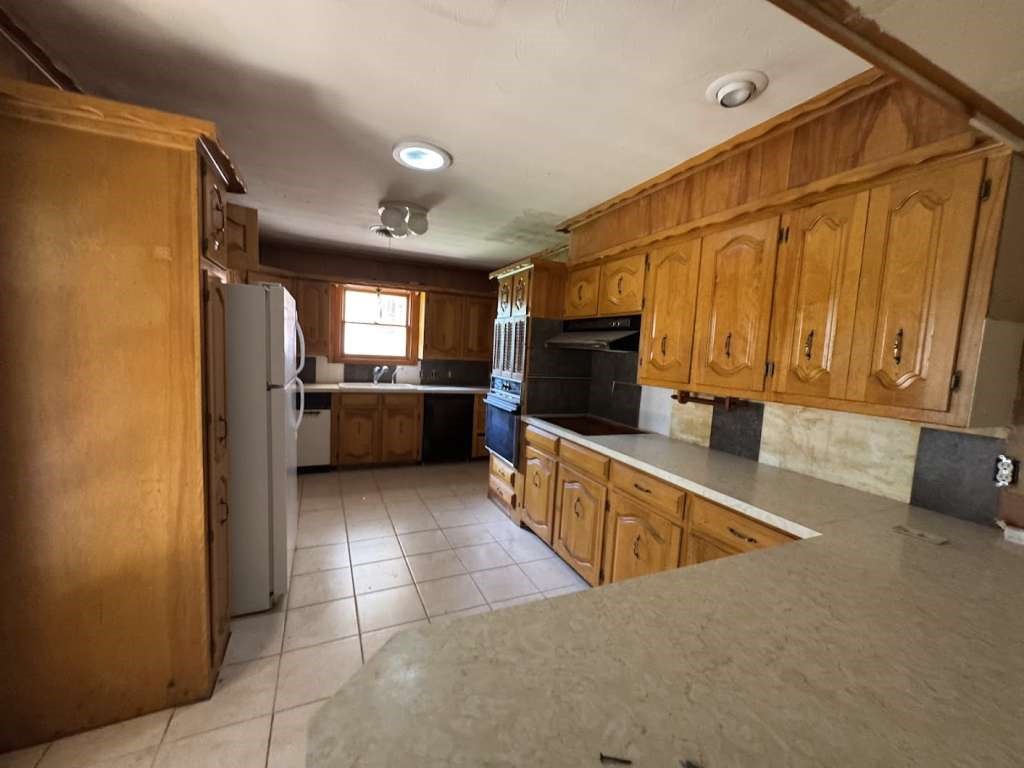 104 East 19th Street Littlefield, TX 79339 - Photo 9 of 19 a kitchen with granite countertop a refrigerator and a sink