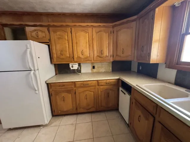 a kitchen with a refrigerator sink and cabinets