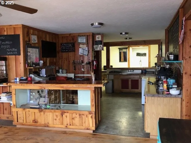 a kitchen with a sink and a stove with wooden floor