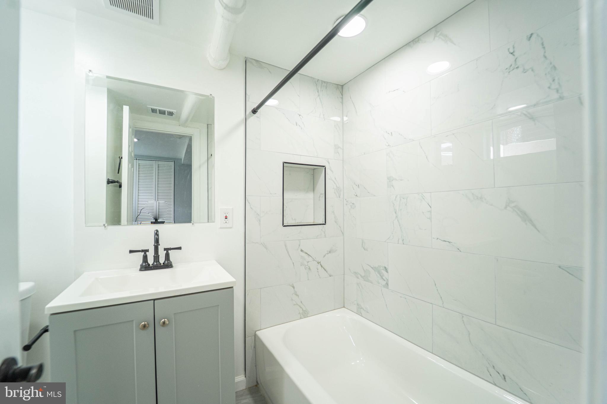 2841 Federal Street Baltimore, MD 21213 - Photo 23 of 39 a bathroom with a sink a shower and a mirror