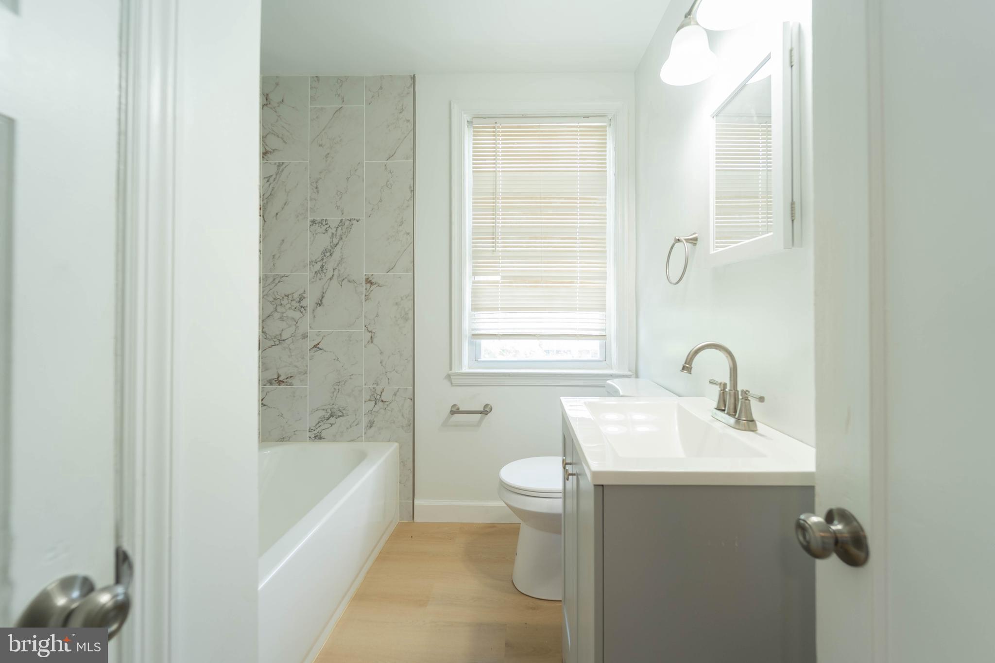 2841 Federal Street Baltimore, MD 21213 - Photo 28 of 39 a bathroom with a sink mirror toilet and bathtub