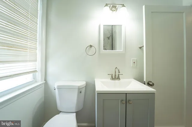a bathroom with a toilet sink and mirror