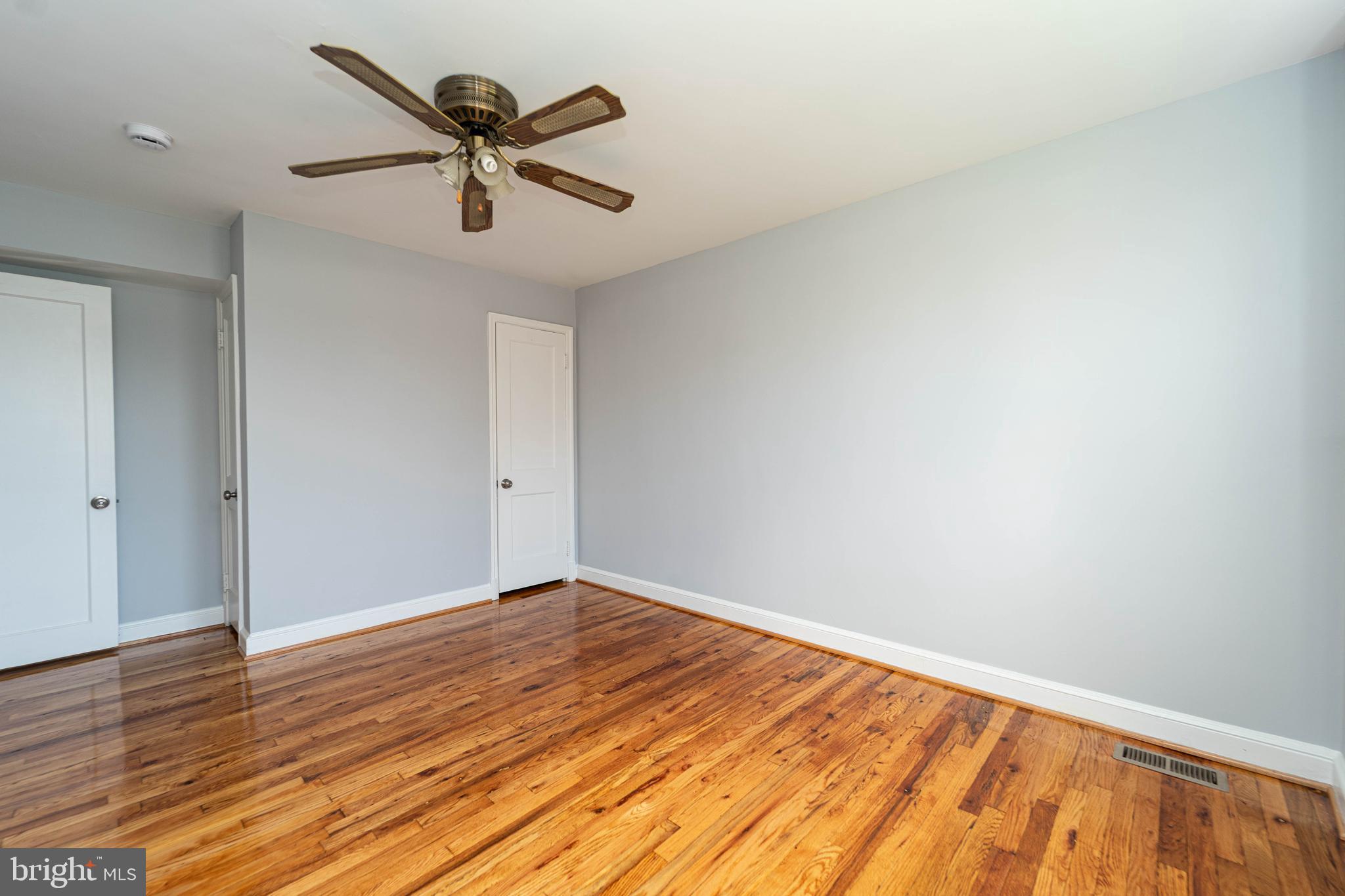 2841 Federal Street Baltimore, MD 21213 - Photo 32 of 39 an empty room with wooden floor and ceiling fan