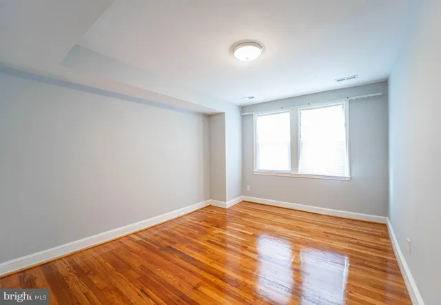 a view of empty room with wooden floor