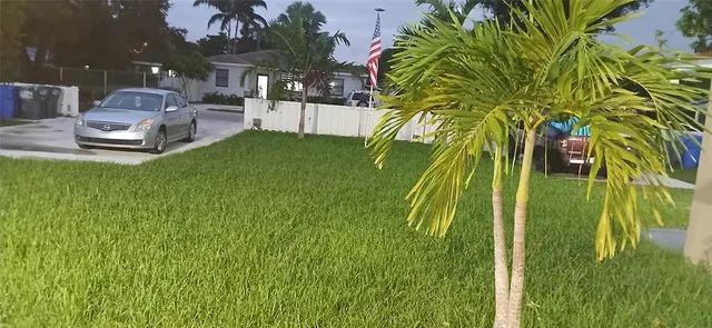 a swimming pool with some potted plants and large trees