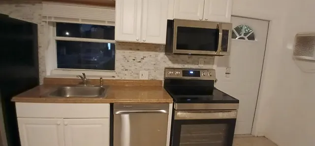 a kitchen with a sink stove and microwave