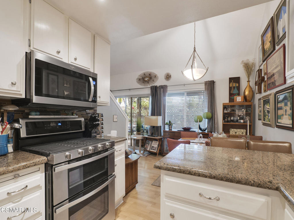24829 Apple Street, Unit E Newhall, CA 91321 - Photo 14 of 29 a kitchen with stainless steel appliances granite countertop a stove a sink and a microwave