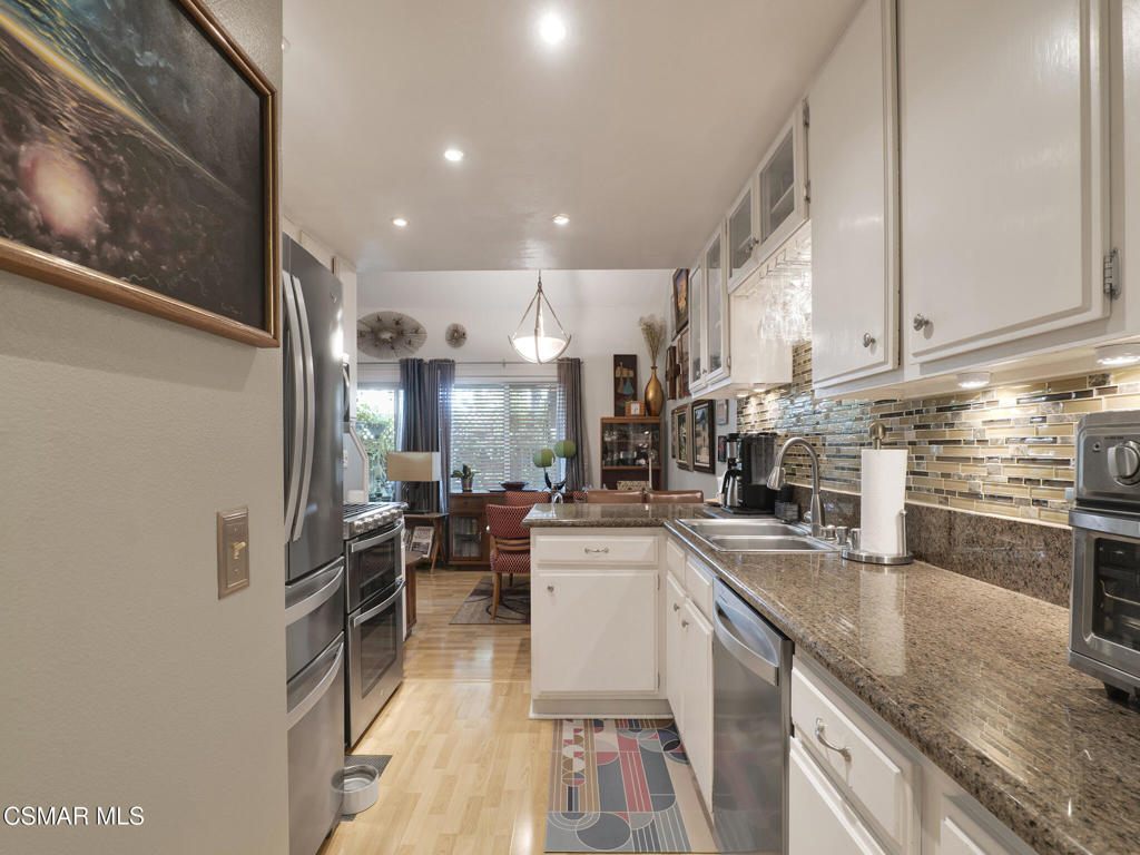 24829 Apple Street, Unit E Newhall, CA 91321 - Photo 15 of 29 a kitchen with counter top space a sink appliances and cabinets