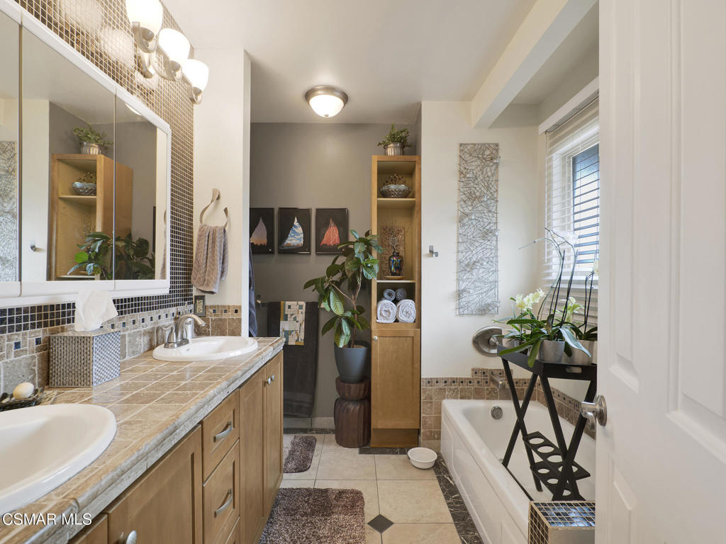 24829 Apple Street, Unit E Newhall, CA 91321 - Photo 21 of 29 a bathroom with a granite countertop sink a large mirror and a shower