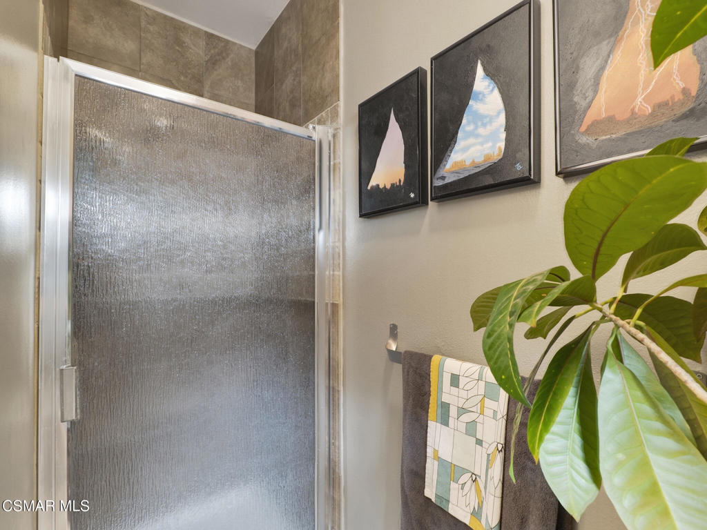 24829 Apple Street, Unit E Newhall, CA 91321 - Photo 22 of 29 a bathroom with a mirror and a shower