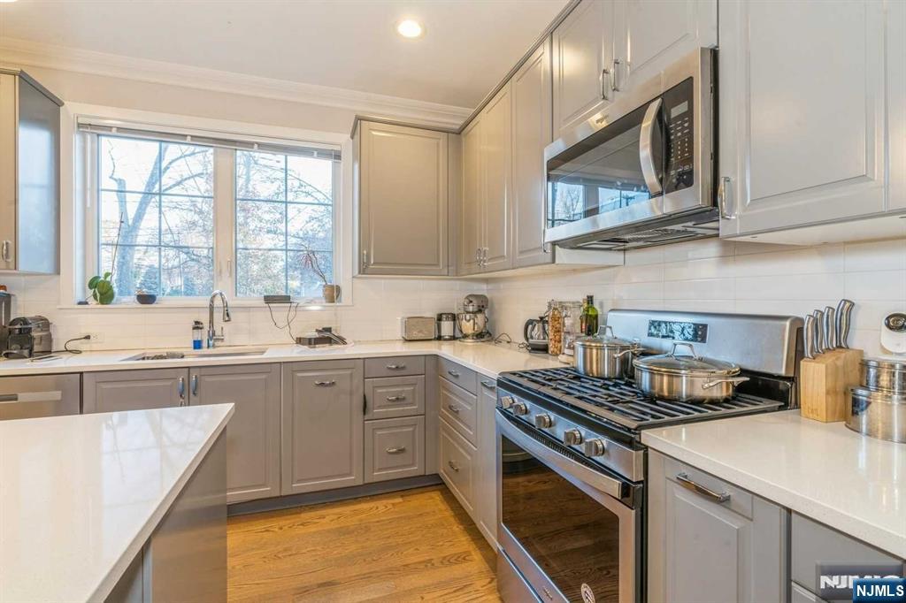5 Benjamin Road Tenafly, NJ 07670 - Photo 14 of 50 a kitchen with stainless steel appliances granite countertop a stove a sink and a microwave