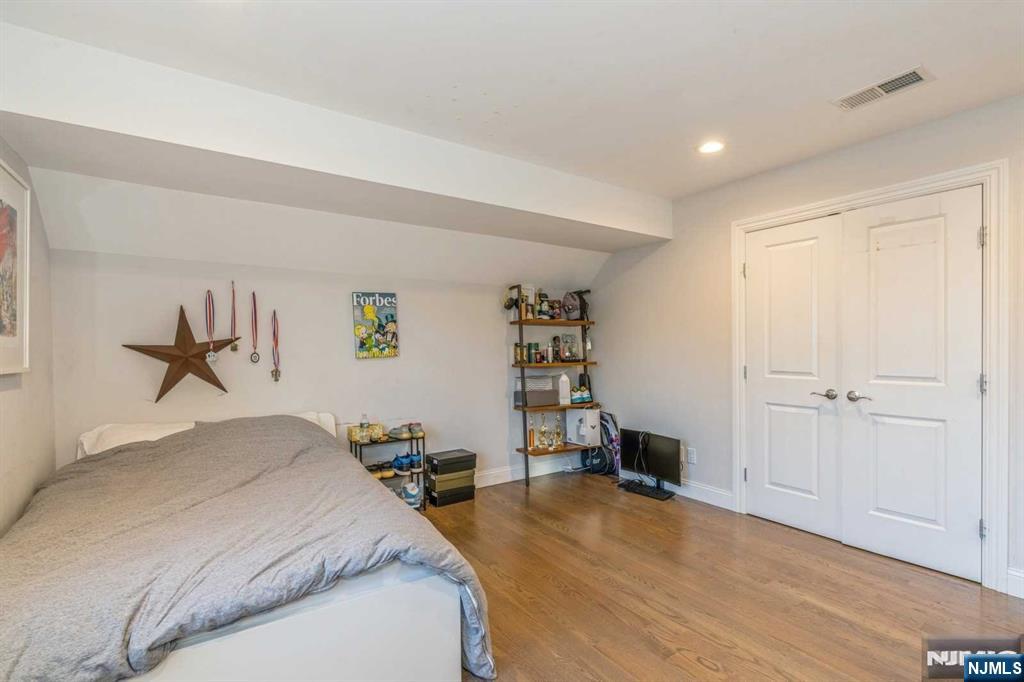 5 Benjamin Road Tenafly, NJ 07670 - Photo 22 of 50 a spacious bedroom with a bed and a chandelier