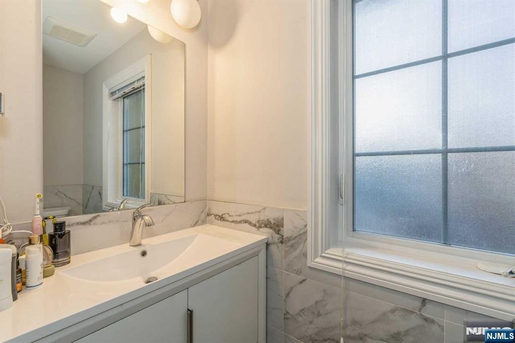 5 Benjamin Road Tenafly, NJ 07670 - Photo 27 of 50 a bathroom with a sink and a mirror