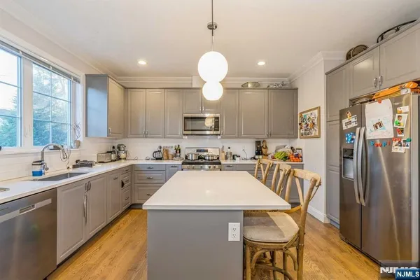 a kitchen with refrigerator a sink and chairs