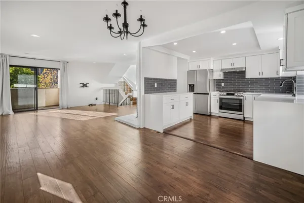 a large kitchen with cabinets wooden floor and stainless steel appliances