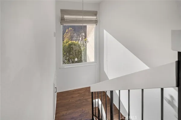 a view of a hallway with wooden floor and staircase