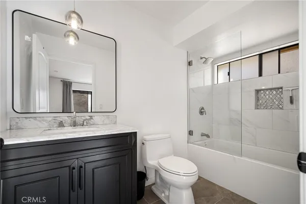 a bathroom with a sink a toilet and a large mirror