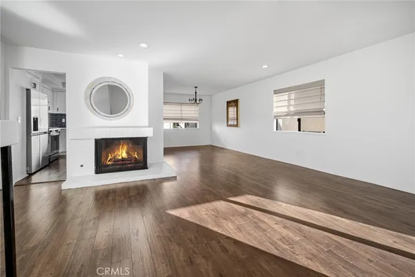 a living room with wooden floor and a fireplace
