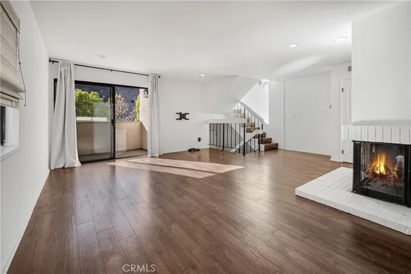 a view of empty room with wooden floor and fireplace