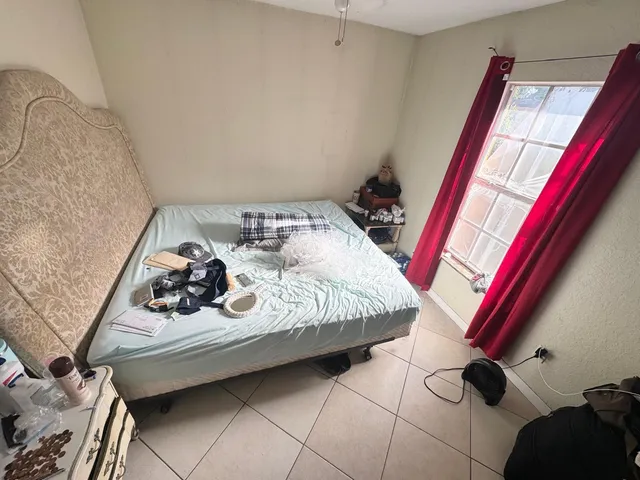 a bed sitting in a bedroom next to a window