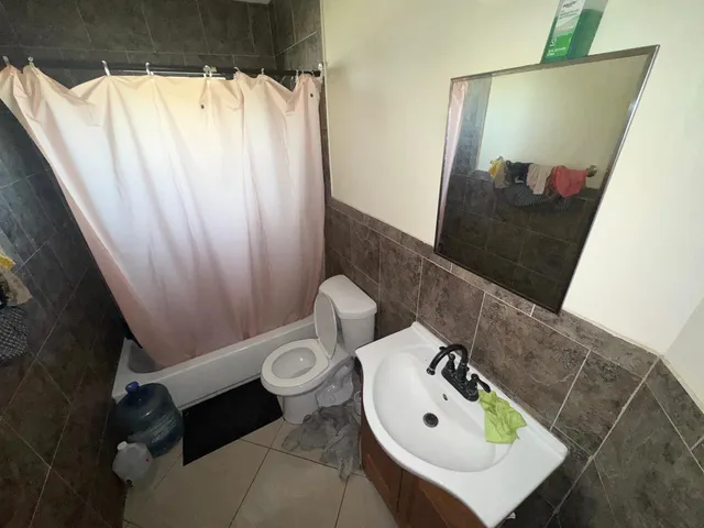 a bathroom with a sink and mirror with toilet