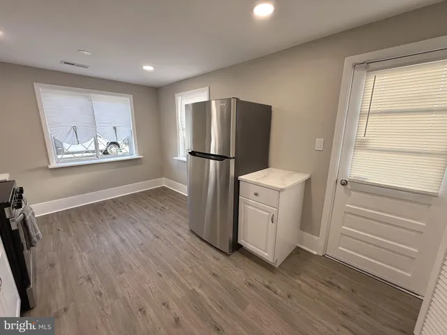 a view of kitchen with wooden floor and electronic appliances