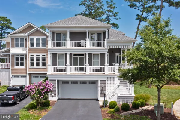a front view of a house with a yard and trees