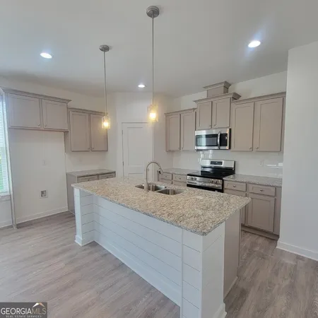 a kitchen with a sink a stove a center island and cabinets