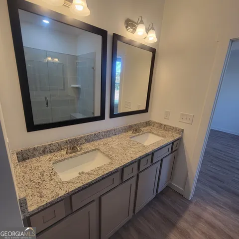 a bathroom with a granite countertop sink and a mirror