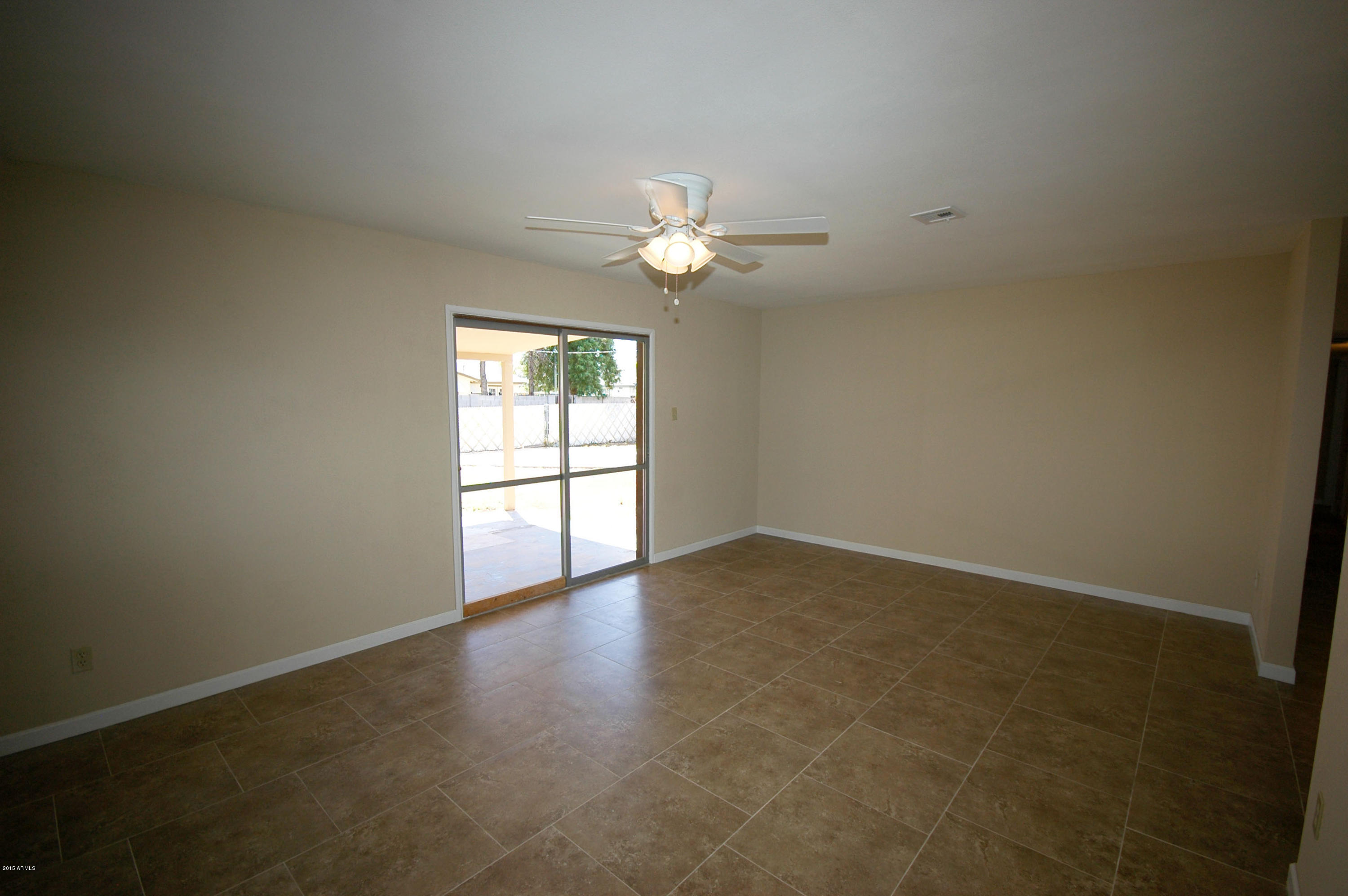 3151 West Redfield Road Phoenix, AZ 85053 - Photo 7 of 15 an empty room with chandelier fan and windows