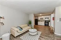 a living room with furniture and kitchen view