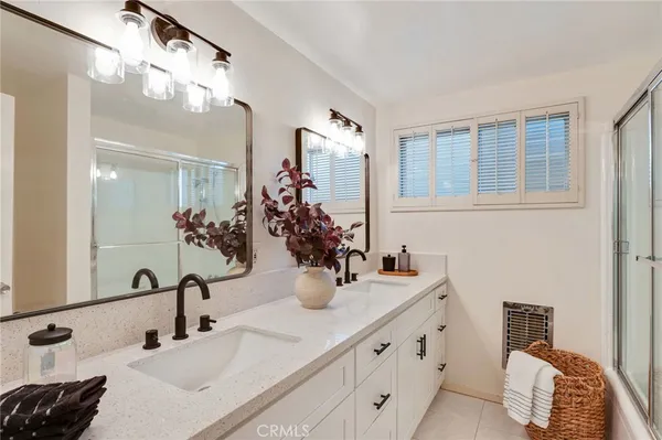 a bathroom with double vanity and a mirror