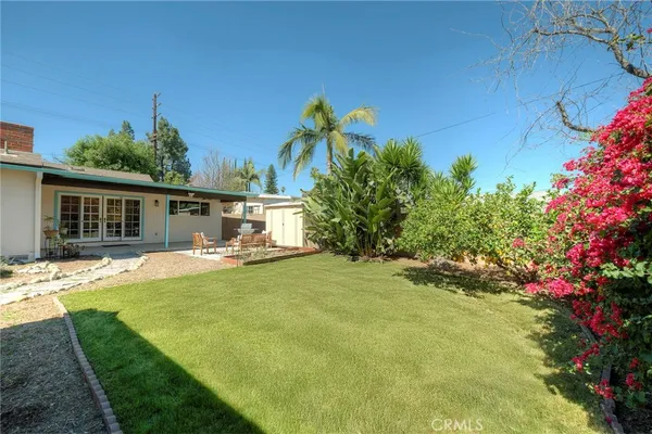a view of a house with swimming pool and a yard