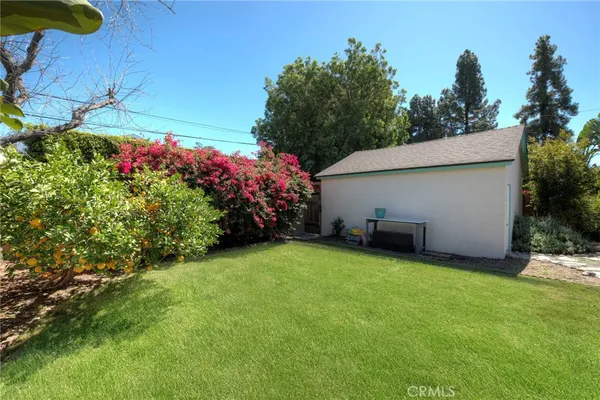 a view of a house with a big yard and potted plants