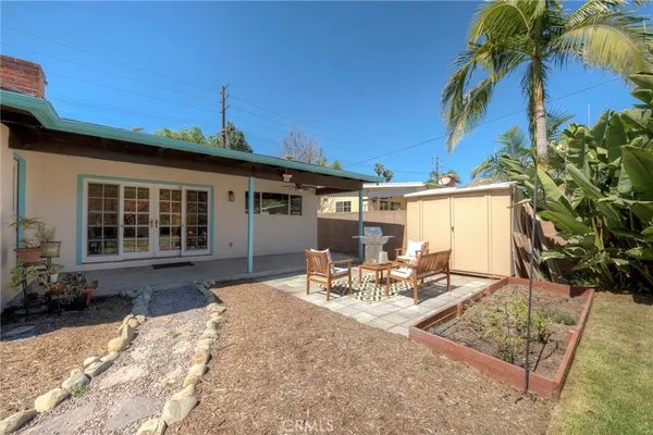 a view of a backyard with table and chairs and potted plants