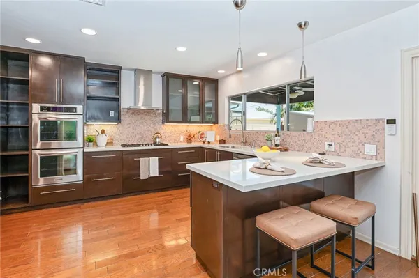 a kitchen with a sink a counter top space stainless steel appliances and cabinets
