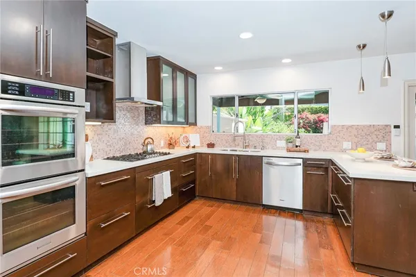 a kitchen with stainless steel appliances granite countertop a sink stove and cabinets