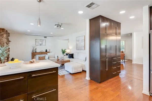 a kitchen view with stainless steel appliances kitchen island granite countertop a refrigerator and a sink