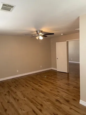 a view of an empty room with wooden floor