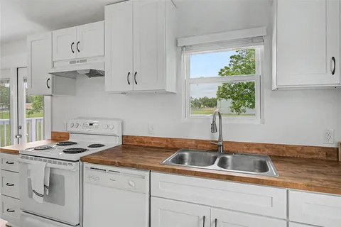 a kitchen with white cabinets and a sink