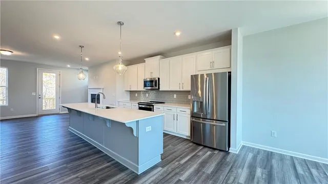a kitchen with stainless steel appliances granite countertop a sink and a microwave