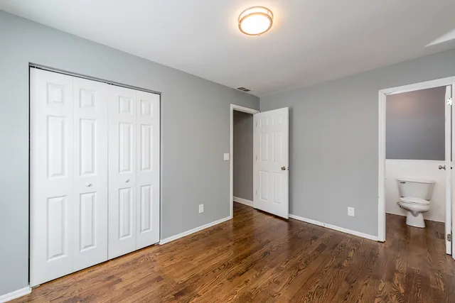 a view of a room with wooden floor and bathroom view