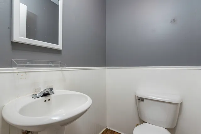 a bathroom with a toilet a sink and mirror